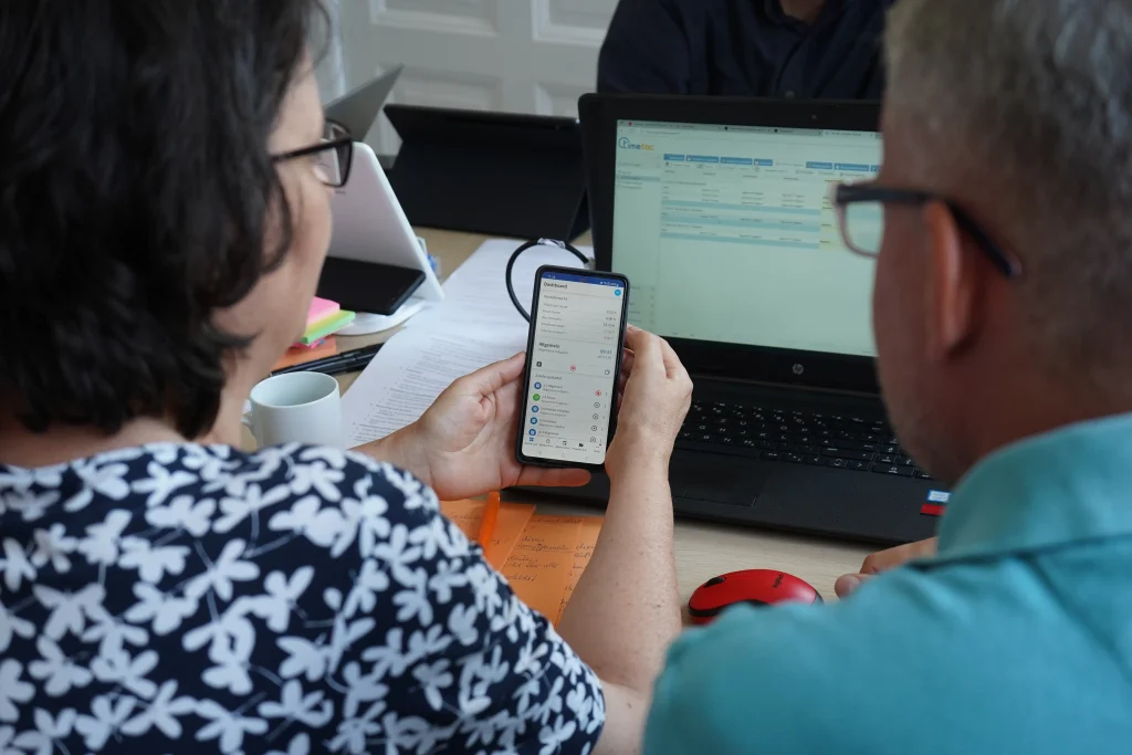 Zwei Personen testen eine Lösung zur digitalen Zeiterfassung