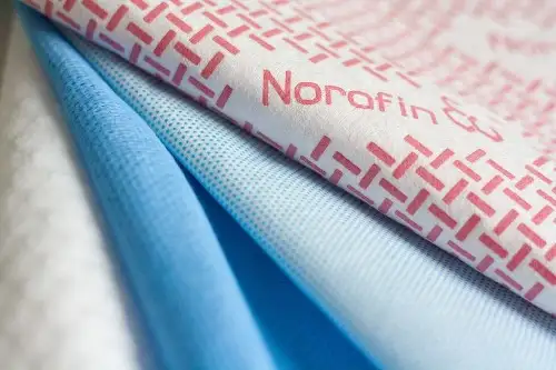 Auf dem Bild sind verschiedene Vliesstoffe, die Norafin Industries (Germany) GmbH im Sortiment hat, abgebildet.