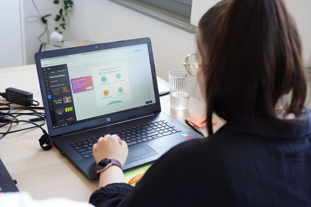 Eine Frau schaut auf einen Laptop und erstellt Grafiken über Design-Lösungen