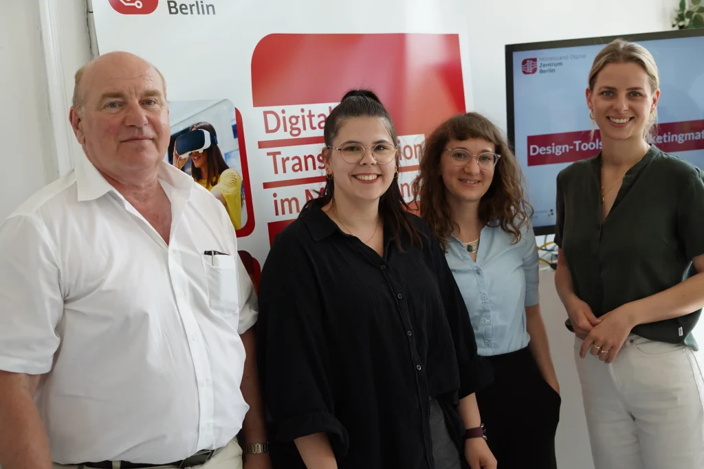Vier Personen stehen zusammen für ein Foto und blicken in die Kamera