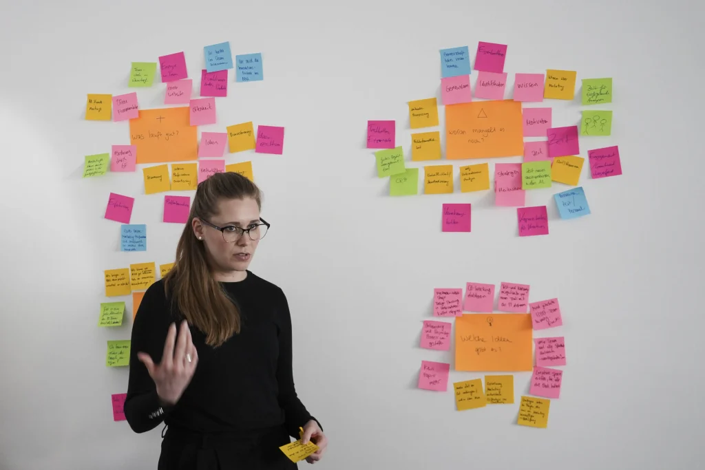 BBQ-Mitarbeitern präsentiert Ihre Ideen auf einer Wand voller Post-Its