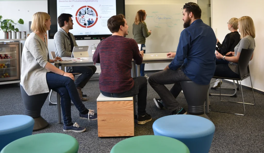 Mitarbeitende arbeiten in einem Workshop zusammen.