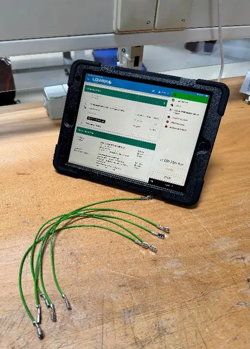 Auf dem Bild ist ein Tablet zu sehen, auf der eine Software ausgeführt wird. Zudem sind Kabel zu sehen.