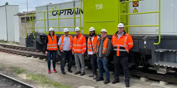 Das Projektteam steht vor einer Lokomotive