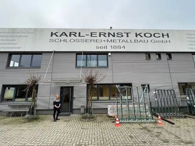 Betriebsfassade Karl-Ernst Koch Schlosserei + Metallbau GmbH mit der Geschäftsführerin im Vordergrund