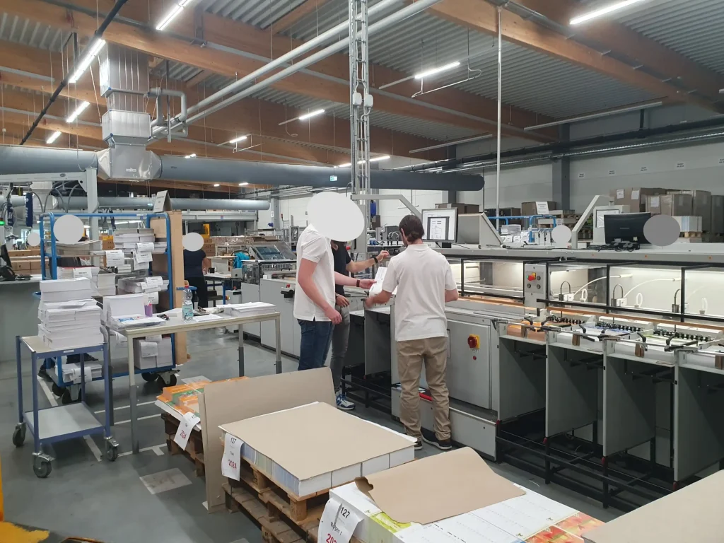 Mitarbeiter stehen in der Halle und arbeiten zusammen
