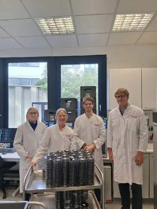 Zwei weibliche Mitarbeiter der Firma KEBOS und zwei männliche Wissenschaftliche Mitarbeiter der TUHH, alle in weißen Laborkitteln