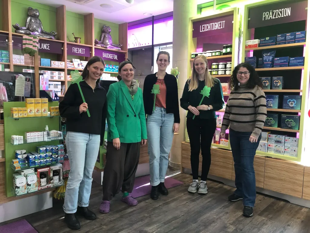 Auf dem Bild sind 5 Personen in einer Apotheke zu sehen.